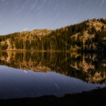 Star trails mirrored on the surface of a small lake in Yosemite National Park