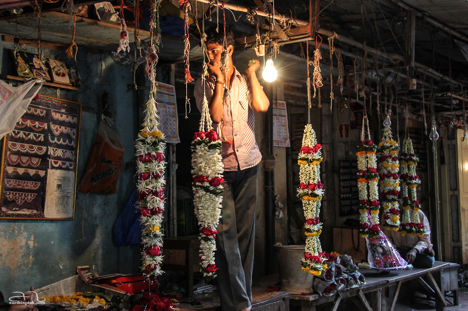 A boy selling flower garlands at a market in Mumbai, India