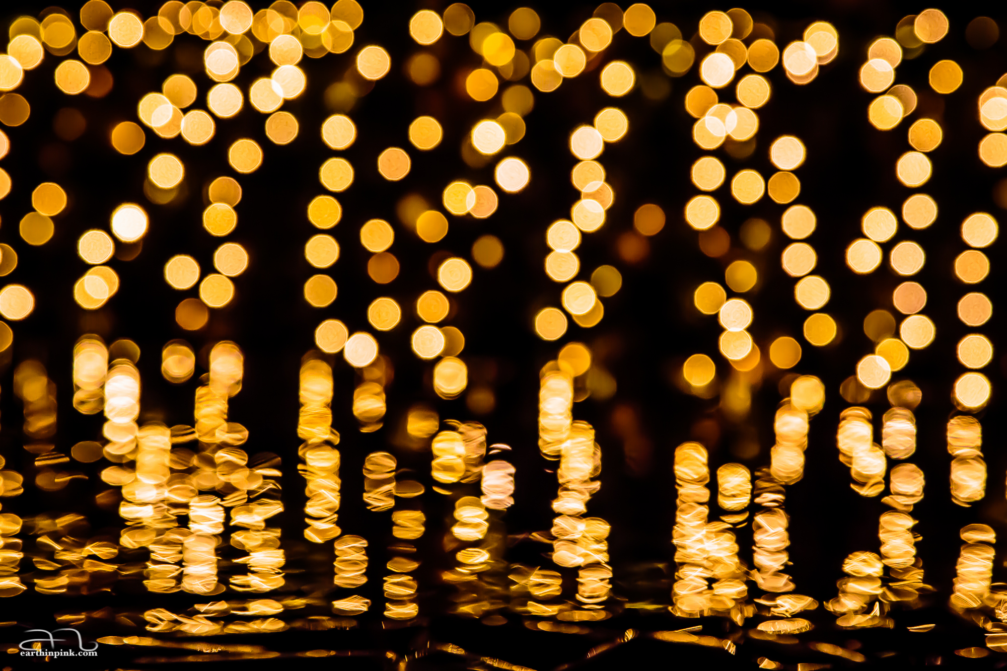 This was taken just outside Osaki station; distant, out of focus lights are reflected on the surface of a little pond, which makes them look like falling golden coins.